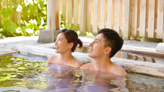 温泉につかるカップル