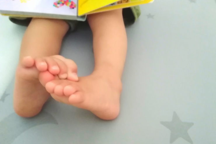 絵本を読んでいる子供の足